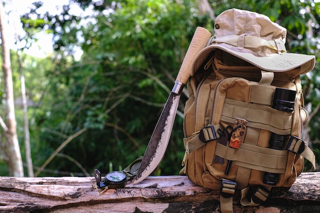 Saco de faca com equipamento para sobrevivência na floresta em uma velha madeira de madeira