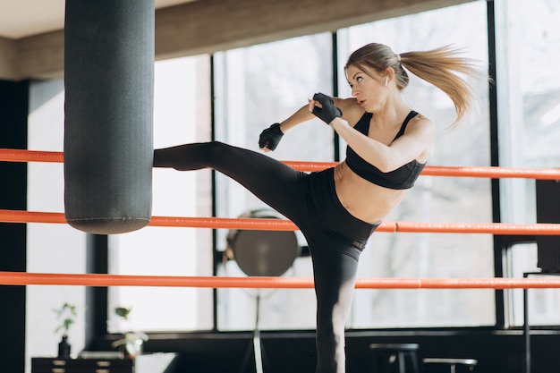 Saco de pancadas de treinamento de mulher kickboxing na força feroz de fitness cabe o corpo