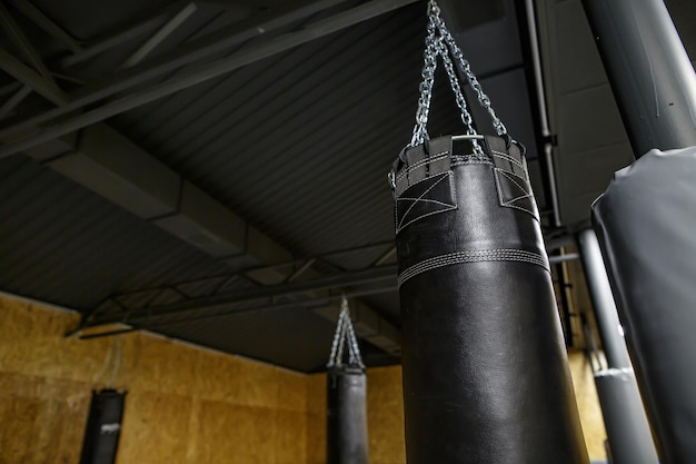 Saco de pancadas preto na sala vazia cheia de fumaça isolada em preto