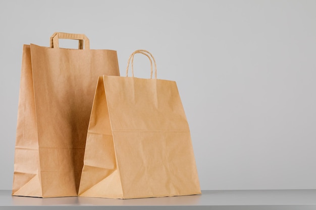 Saco de papel pardo com alças de saco de compras vazio com área para o seu logotipo ou conceito de entrega de comida de design