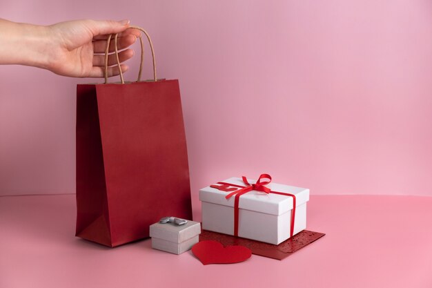 Saco de papel vermelho de São Valentim, presentes em caixas com fita. Copie o espaço.