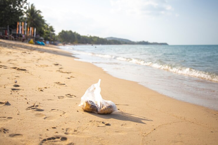 saco de plástico deitado em uma praia tropical. poluição ambiental. lixo no mar