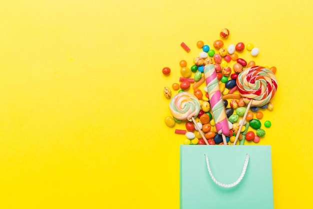 saco de presente de papel de compras no canto cheio de variados doces tradicionais caindo em fundo colorido com espaço de cópia conceito de venda de feriados felizes