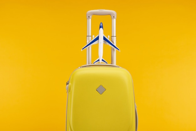 Saco de viagem colorido amarelo com avião de brinquedo isolado em amarelo