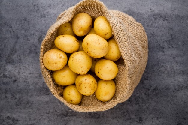 Un saco marrón de patatas crudas frescas