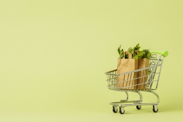 Sacolas de papel com salada verde fresca no carrinho