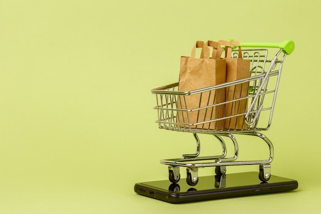 Foto sacolas de papel com salada verde fresca no carrinho