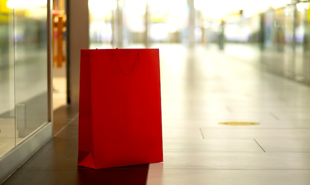 Sacolas de papel vermelho paradas no fundo do shopping