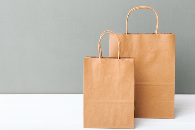 Foto sacos de papel artesanal marrom. sacos de compras em fundo branco mesa cinza com espaço de cópia