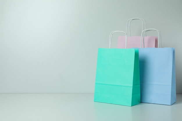 Foto sacos de papel coloridos em branco sobre fundo branco, espaço para texto