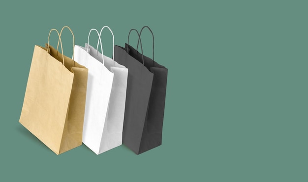 Sacos de papel para fazer compras em fundo verde Copiar espaço