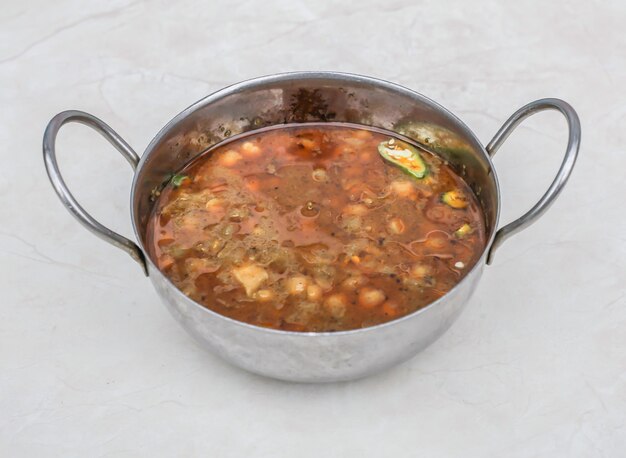 Foto sada chanay channay chole o curry de garbanzos servido en karahi aislado en un fondo gris vista lateral del desayuno pakistaní y las especias indias comida