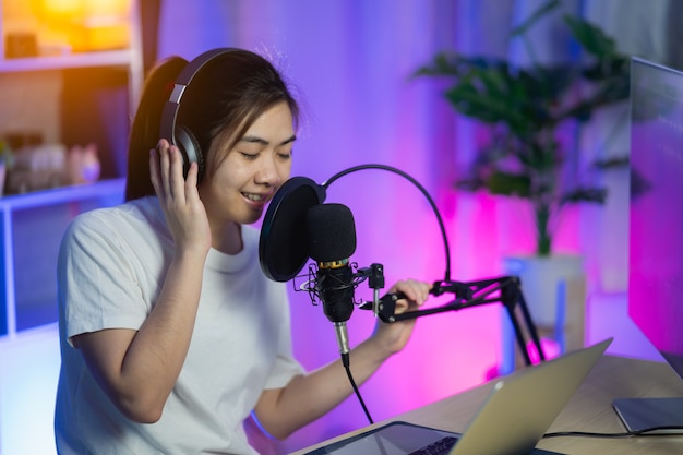 Sängerinnen singen mit Kopfhörern, die im Home-Recording-Studio ein neues Lied aufnehmen