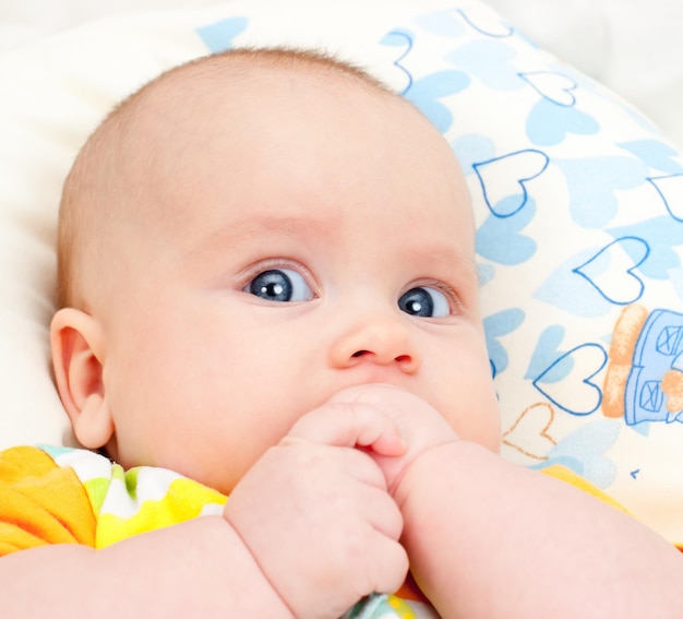 Säugling mit den Händen im Mund