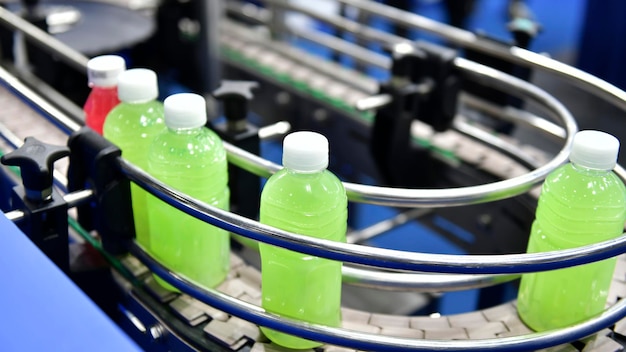 Saftflaschen aus Kunststoff werden auf automatisierten Fördersystemen für die industrielle Automatisierung für Verpackungen übertragen