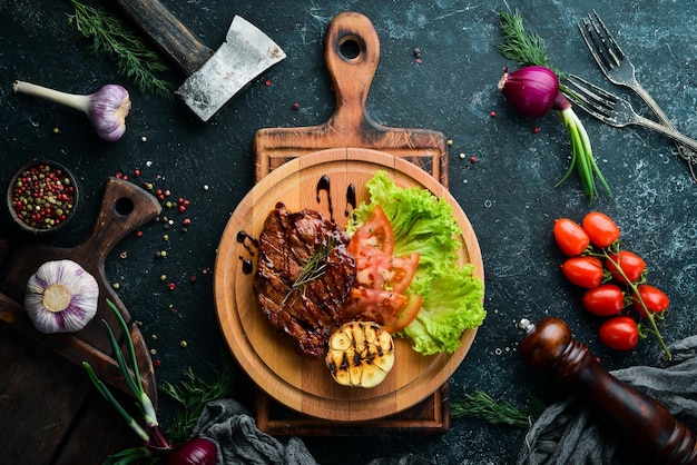 Saftig gebackenes Schweinesteak mit Gemüse auf dem Brett Draufsicht