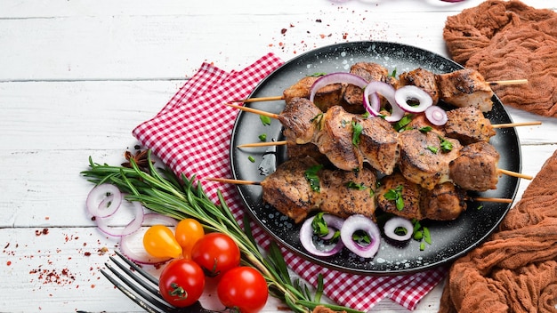 Saftige Fleischspieße in einem schwarzen Teller Barbecue-Kebab Draufsicht Freier Kopierbereich