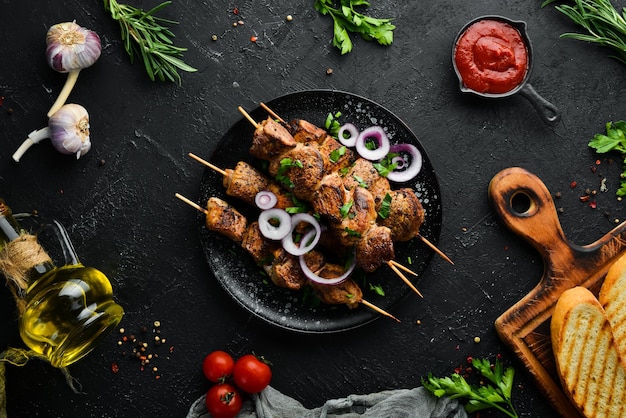 Saftige Fleischspieße in einem schwarzen Teller Barbecue-Kebab Draufsicht Freier Kopierbereich