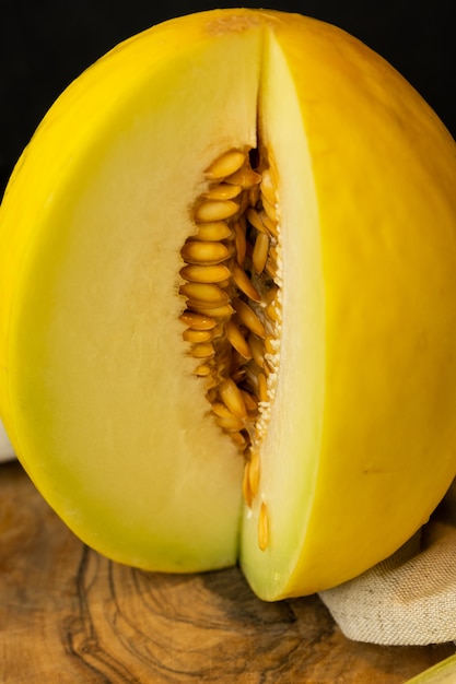 saftige gelbe Melone geschnitten mit einer Scheibe auf einer dunklen Oberfläche