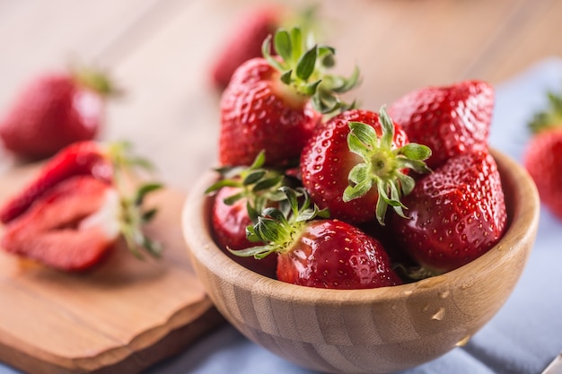 Saftige gewaschene Erdbeeren in Holzschale auf Küchentisch.