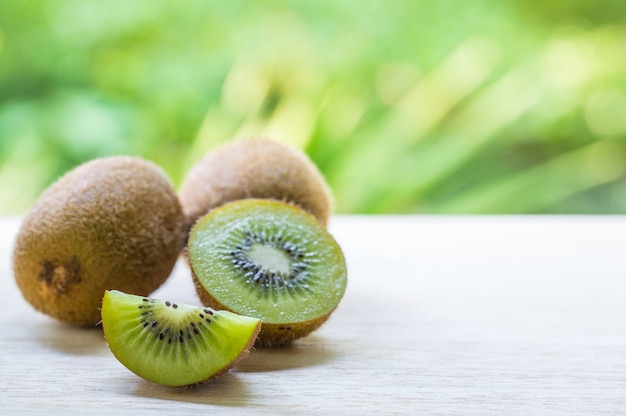 Saftige Kiwi auf Holztisch auf grünem Hintergrund