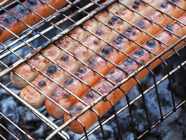 Saftige leckere Würste auf dem Grill werden im Grill auf den Kohlen gebraten