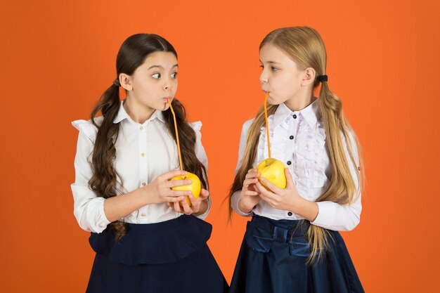 Saftige Äpfel. Schulkinder mit gesundem Apfelsnack. Nette Schulmädchen, die Äpfel halten. Kleine Mädchen, die eine Schulsnackpause machen. Kleine Mädchen, die natürliche Vitaminnahrung essen Früchte sind reich an Vitaminen.