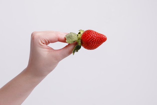 Saftige rote Erdbeeren in der Hand auf weißem Hintergrund