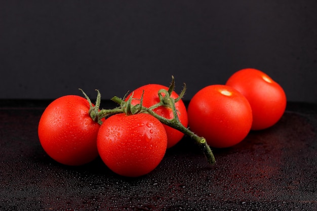Saftige süße rote Tomaten auf schwarzem Hintergrund Konzept für gesunde Ernährung Nahaufnahme