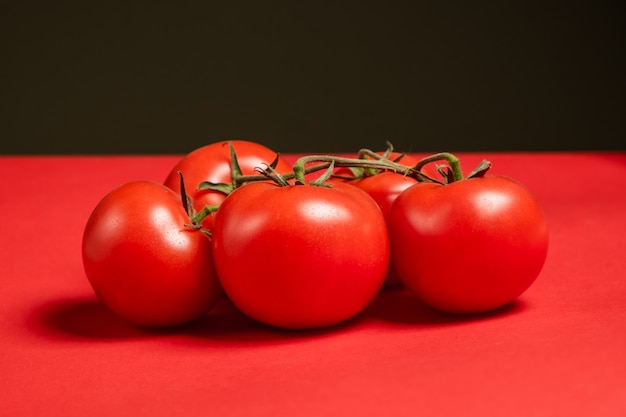 Saftige Tomaten auf einer leuchtend roten Oberfläche