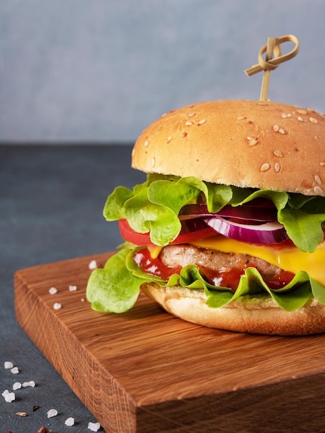 Saftiger hausgemachter Burger mit Fleisch und Gemüse auf einer Holzbrettnahaufnahme