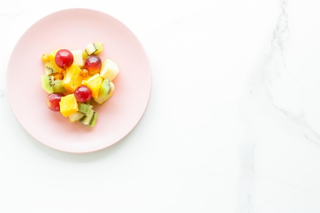 Saftiger Obstsalat zum Frühstück auf Marmor-Flatlay-Diät und gesundem Lifestyle-Konzept