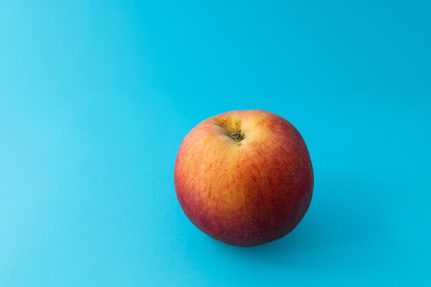 Saftiger roter Apfel auf blauem Hintergrundthema Lebensmittelaufnahme