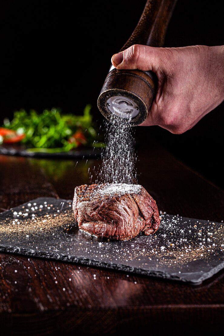 Saftiges gegrilltes Schweinefleisch auf einem schwarzen Teller