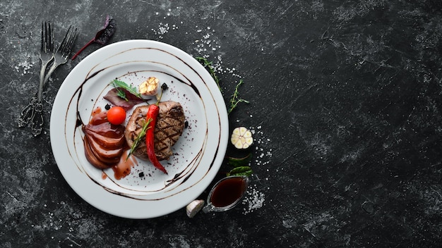 Saftiges Kalbssteak mit Chilischote und Birne auf einem Teller Draufsicht Freier Kopierplatz