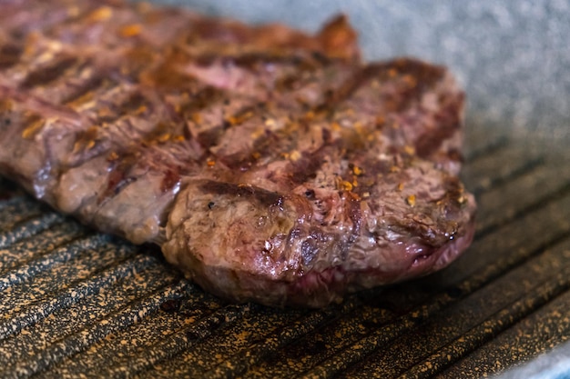 Saftiges Rindersteak, das auf einer Grillpfanne in der professionellen Küche gekocht wird. Prime Steak Braten im Grill del