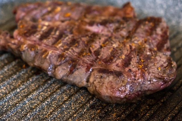 Saftiges Rindersteak, das auf einer Grillpfanne in der professionellen Küche gekocht wird. Prime Steak Braten im Grill del