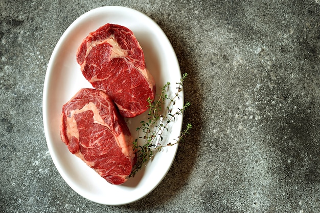 Saftiges rohes Steak mit Thymian auf einem Teller