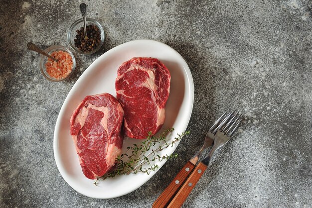 Saftiges rohes Steak mit Thymian auf einem Teller