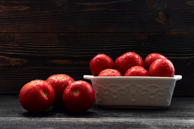 Saftiges rotes Tomatenstillleben auf dunklem Hintergrund