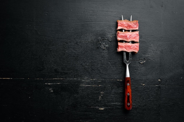 Foto saftiges steak auf der gabel mit kräutern und gewürzen draufsicht freier platz für ihren text