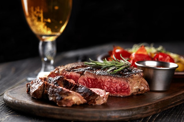 Saftiges Steak Medium Rare Beef mit Gewürzen auf Holzbrett auf dem Tisch