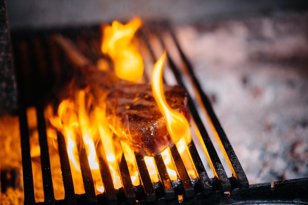 Saftiges Steak wird in einem Restaurant gegrillt. Braten von Fleisch im Feuer auf dem Grill.