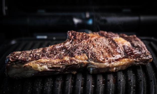 Saftiges Stück Rindersteak auf einem mit Gewürzen gewürzten Grill