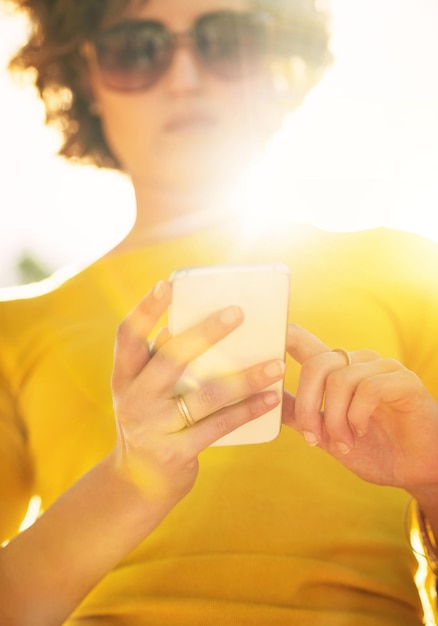 Sagen Sie mit intelligenter Technologie, was Sie wollen Schnappschuss einer nicht erkennbaren jungen Frau, die draußen ein Smartphone benutzt