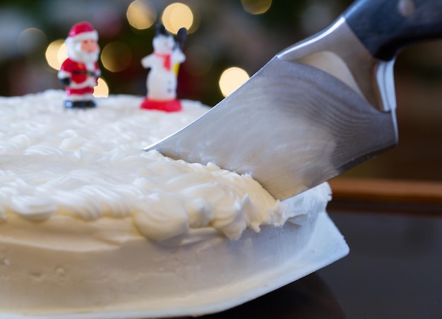 Sahnehäubchen auf Weihnachtskuchen mit Baumlichtern