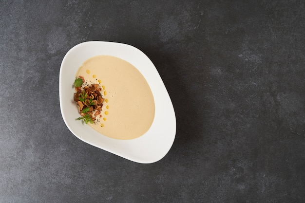 Sahnesuppe mit Brassenfisch auf grauem Hintergrund mit Kopienraum, Nahaufnahme