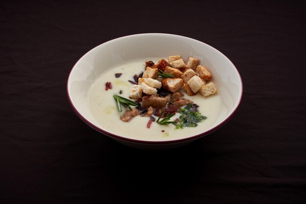 Sahnesuppe mit Steinpilz mit Croutons auf einem Tisch