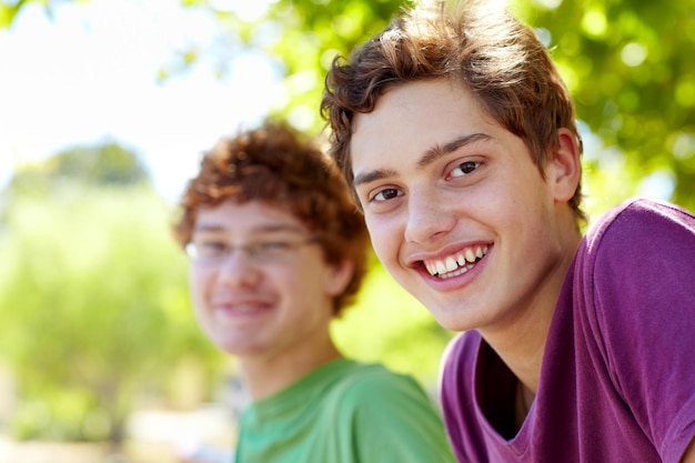 Saindo com meu melhor amigo Retrato de dois meninos sentados em um parque em um dia ensolarado