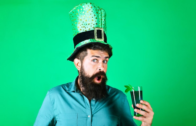 Saint patricks day überraschte den bärtigen mann im koboldhut, der grünes bier mit kleeblattblättern hielt